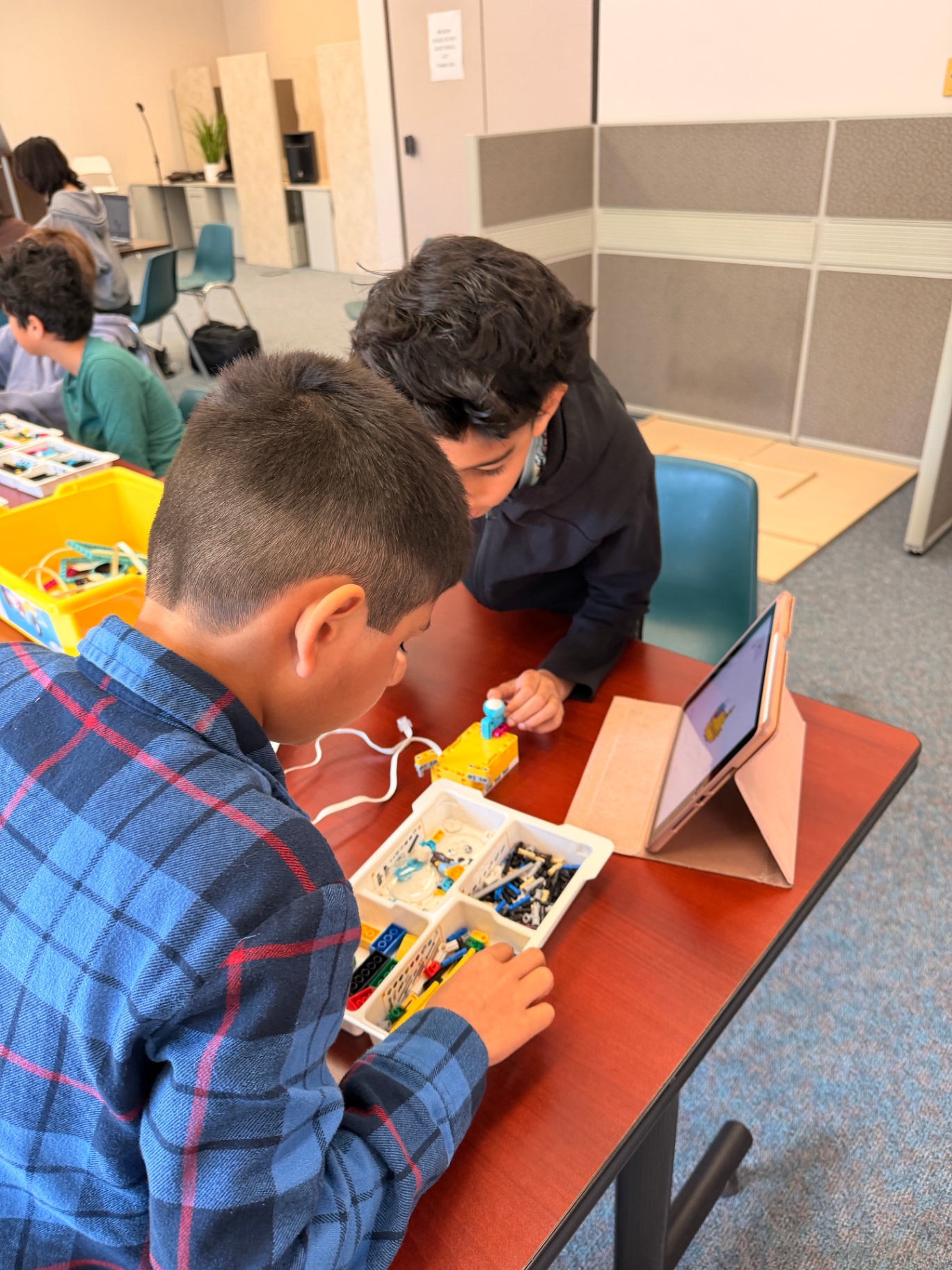 Students prototyping with robotics and tablets in pairs